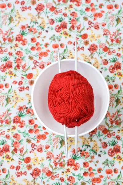 Белая тарелка, спицы, красный и белый шар на фоне красного цветка — стоковое фото