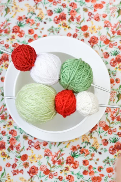 Beaucoup de boules lumineuses de tricot sur le fond d'une fleur rouge — Photo