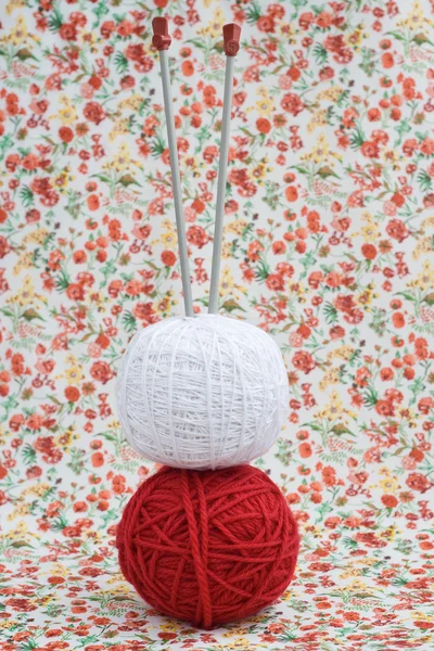 Red and white ball of yarn for knitting and needles on a background — Stock Photo, Image