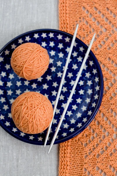 Deux boules de fil rose et aiguilles à tricoter sur une assiette bleue — Photo