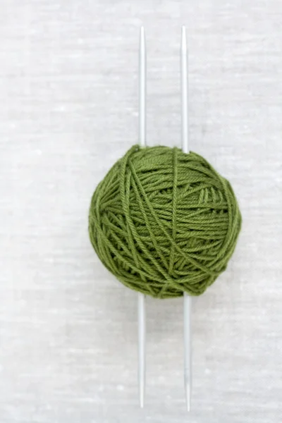 Une grosse boule verte et des aiguilles à tricoter en acier — Photo