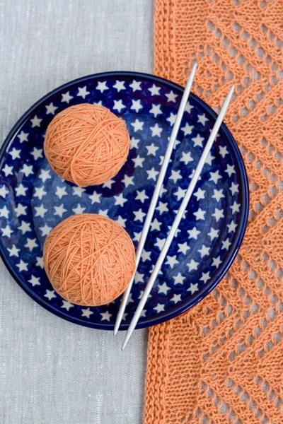 Dos bolas de hilo rosa y agujas de punto en un plato azul —  Fotos de Stock