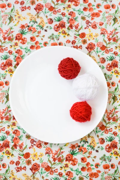白プレート、スポーク、赤い花の背景に赤と白のボール — ストック写真
