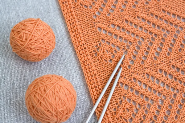 Orange balls, knitted pattern and knitting needles — Stock Photo, Image