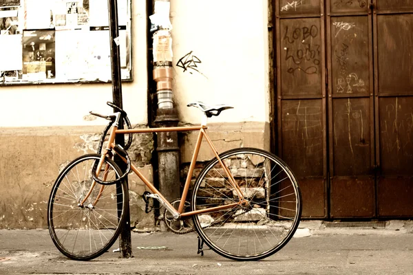 Staré kolo stojící na ulici ve městě — Stock fotografie