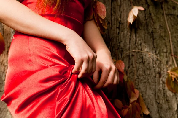 Dziewczynka w czerwonej sukience trzyma ręce — Zdjęcie stockowe