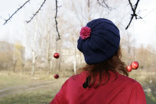 La ragazza con il berretto blu, un maglione rosa e mele rosse — Foto Stock