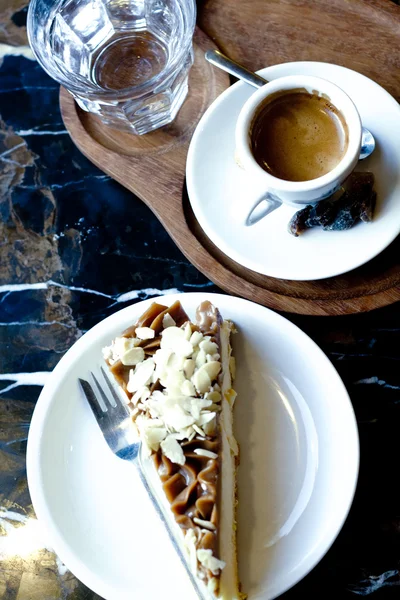 Delicioso pastel de queso, café negro y un vaso de agua — Foto de Stock