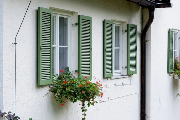 Um fragmento da casa branca com persianas verdes — Fotografia de Stock