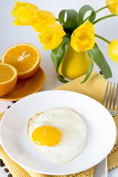 Rührei und Orangen zum Frühstück und gelbe Kanne mit gelben Tulpen — Stockfoto