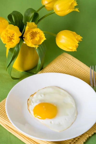 Rührei und Orangen zum Frühstück und gelbe Kanne mit gelben Tulpen — Stockfoto