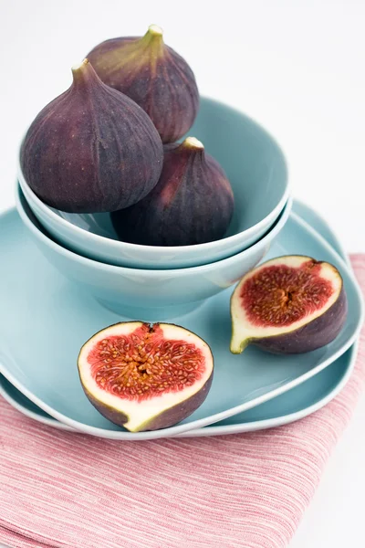 Higos maduros acostados en un plato azul sobre una servilleta rosa —  Fotos de Stock