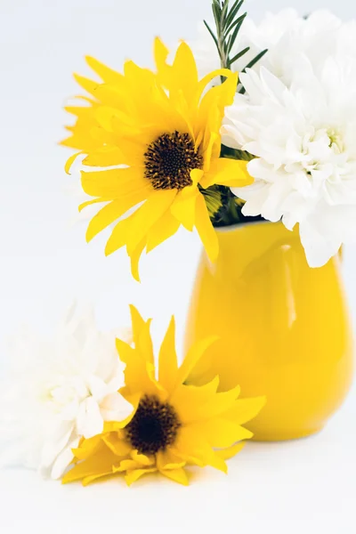 Yellow jug with yellow and white flowers on a light background — Stock Photo, Image