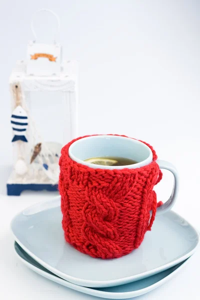 Blaue Tasse mit rotem Stricküberzug und dekorativer Laterne — Stockfoto