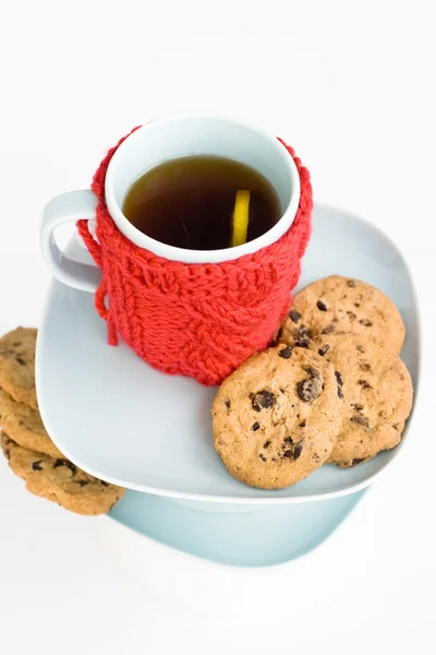 Blauwe cup met rode gebreide kaft en cookies met chocolade — Stockfoto