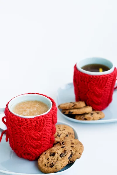 Dvě modré šálky v pletených kryty a čokoládové cookies — Stock fotografie