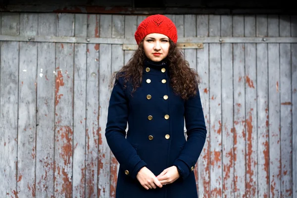 Молодая красивая брюнетка в красном вязаном берет и пальто — стоковое фото