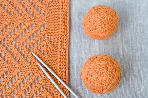 Bolas laranja, padrão de malha e agulhas de tricô — Fotografia de Stock