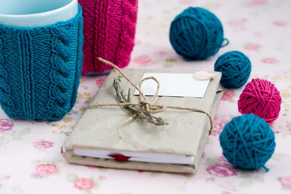 Deux tasses bleues en pull bleu et rose avec boule de fil pour tricoter Images De Stock Libres De Droits