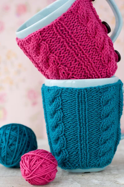 Zwei blaue Tassen in blauem und rosa Pullover mit Garnknäuel — Stockfoto