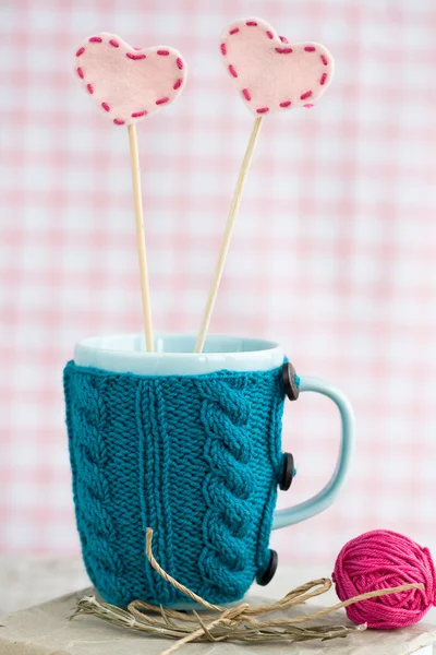 Taza azul en un suéter azul con corazones de fieltro —  Fotos de Stock