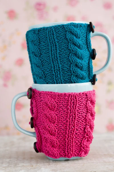 Two blue cups in blue and pink sweater — Stock Photo, Image