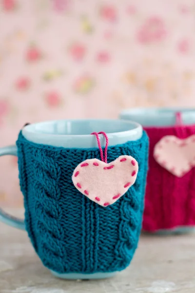 Due tazze blu in maglione blu e rosa con cuori di feltro — Foto Stock