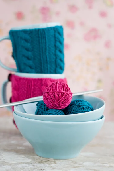 Zwei blaue Tassen in blauem und rosa Pullover mit Kugeln — Stockfoto