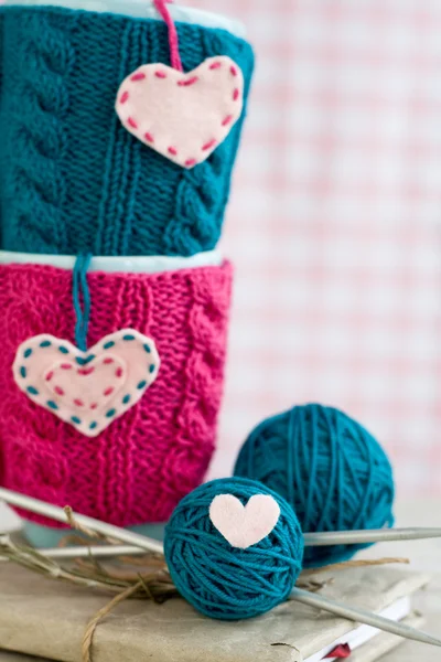 Two blue cups in blue and pink sweater with felt hearts — Stock Photo, Image