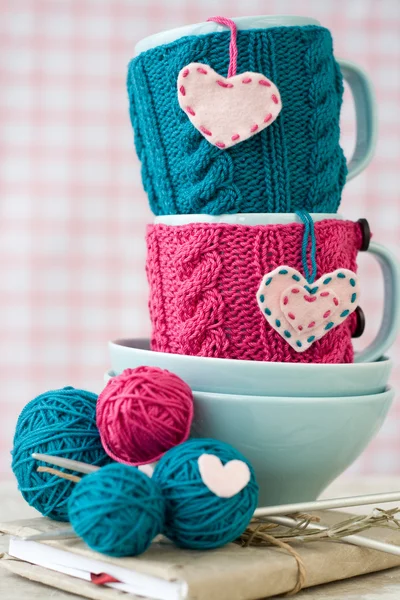 Dwa niebieskie filiżanki w niebieski i różowy sweterek z filcu serca — Zdjęcie stockowe