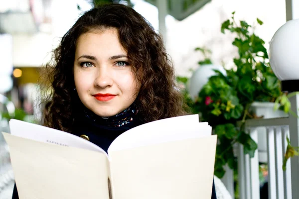 Young beautiful brunette in a street cafe — Stock Photo, Image