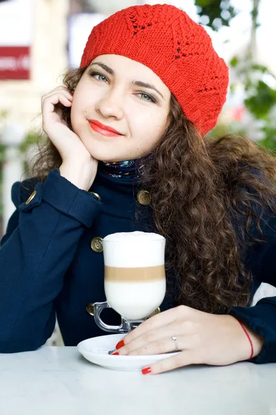 Joven hermosa morena con un delicioso café con leche en una cafetería de la calle — Foto de Stock