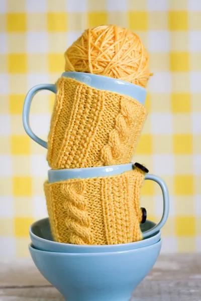 Deux tasses bleues en pull jaune sur un tissu — Photo