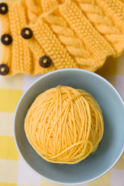 Yellow ball of yarn for knitting in blue plate and pattern — Stock Photo, Image