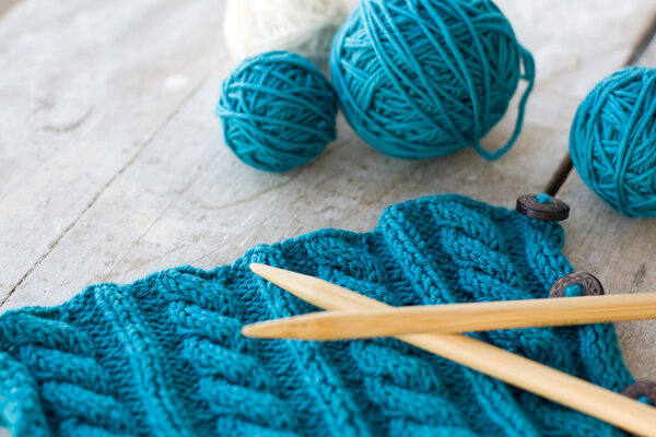 Knitting pattern and needles on a wooden background
