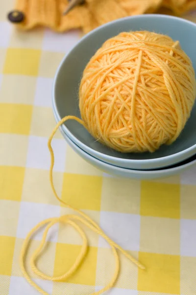 黄色的球，在蓝色的盘子和图案针织用纱 — 图库照片