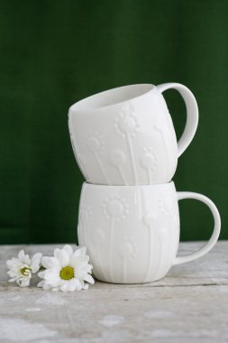 İki fincan yeşil renkli ve beyaz çiçek beyaz