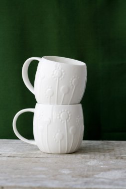 İki fincan yeşil bir arka plan üzerinde beyaz