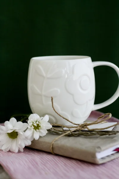 Una taza blanca sobre un fondo verde y portátil vintage —  Fotos de Stock