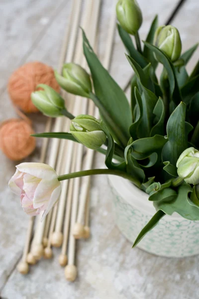 Strauß zarter rosa Tulpen mit Stricknadeln und Wollknäueln — Stockfoto