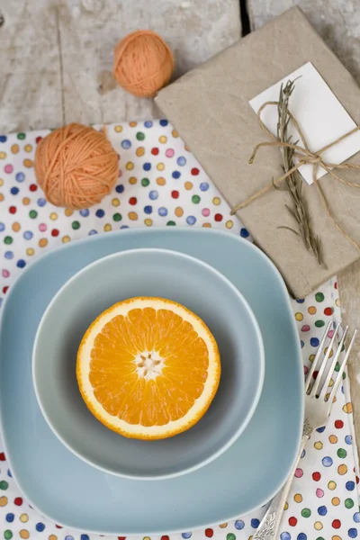 Naranja jugosa en el plato azul es la almohadilla vieja y enredos de hilo — Foto de Stock