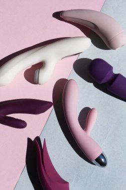 Mavi ve pembe arka planda farklı seks oyuncakları koleksiyonu. Yetişkinler için seks oyuncakları, vibratörler, klitoral uyarıcılar.