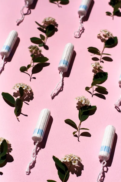 ピンクの背景に医療用メスタンポンと白花を咲かせます 女性のための衛生的な白いタンポン 綿棒だ 精神障害治療 — ストック写真