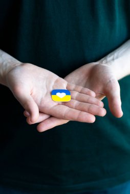 Rusya ile savaşta Ukrayna 'ya destek. Genç bir adam Ukrayna 'nın stilize edilmiş bayrağını tutuyor. Kavramsal fotoğraf.