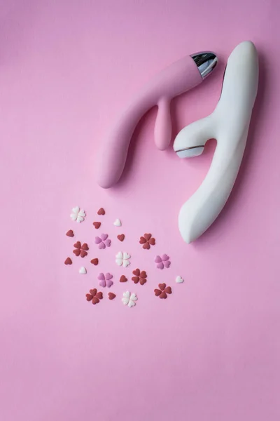 大人のための2つの振動ピンクと白のおもちゃはピンクの背景にあり 装飾的な心の隣にオーガズムを模倣しています 概念写真 — ストック写真
