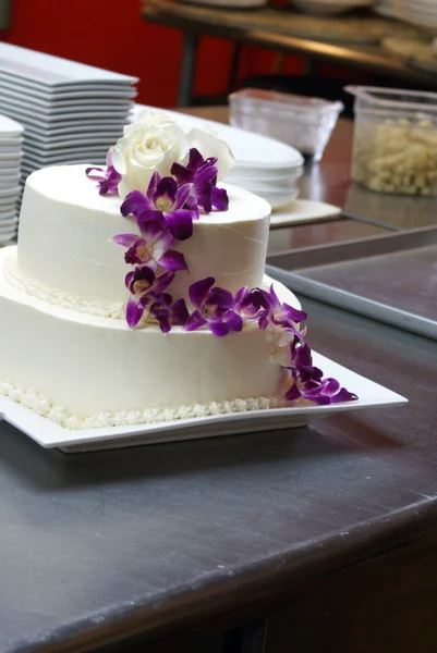 Weiße Hochzeitstorte mit lila Orchideen — Stockfoto