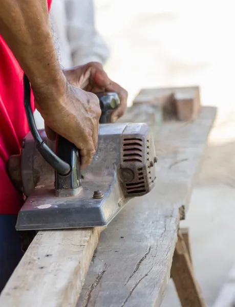 Tischler arbeitet mit elektrischer Hobelmaschine — Stockfoto