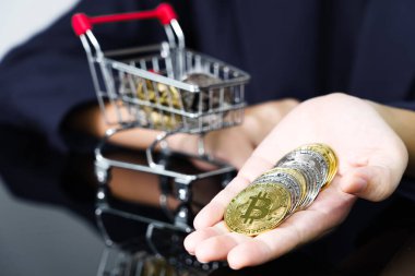 Altın renkli bitcoin tutan ve veren iş kadınlarının yakın plan görüntüsü