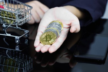 Altın renkli bitcoin tutan ve veren iş kadınlarının yakın plan görüntüsü