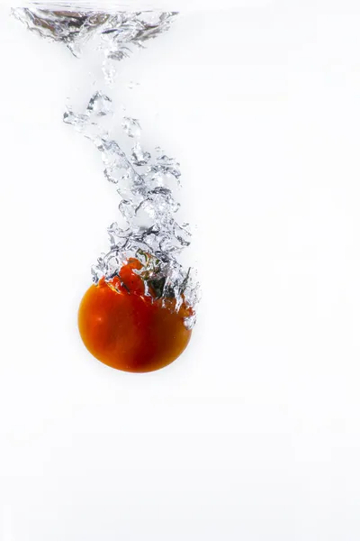 Red tomato splashing into water — Stock Photo, Image